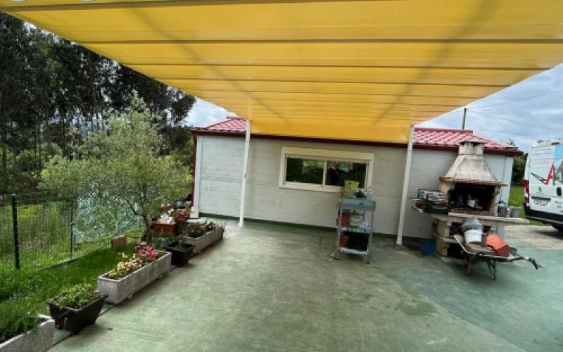 Toldo amarillo grande cerrado en pérgola