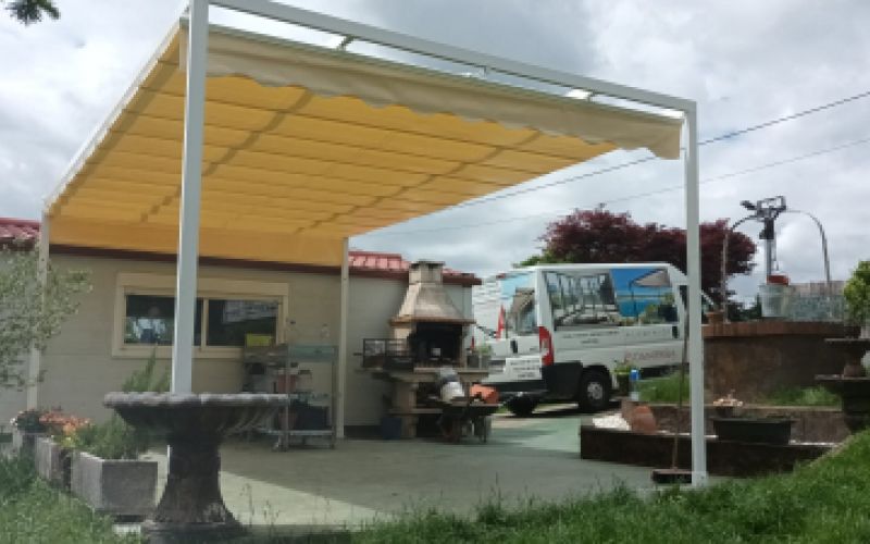 Toldo amarillo cerrado en pérgola