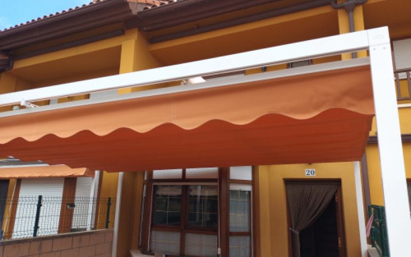 Toldo grande naranja abierto en terraza exterior